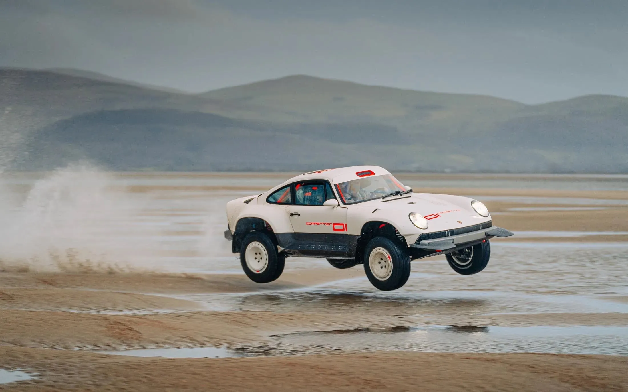 Car on the beach, doing a jump in the sand
